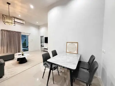 Modern open-plan living and dining area with sleek furniture and ambient lighting.