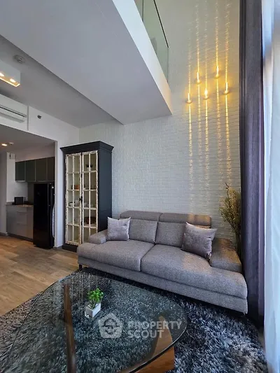 Modern living room with high ceiling and stylish decor in a contemporary apartment.