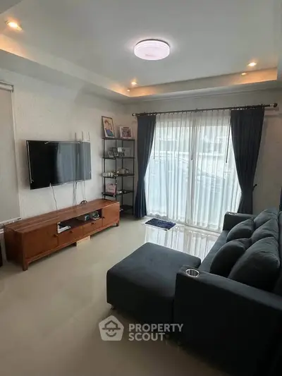 Modern living room with sleek furniture and large window for natural light.