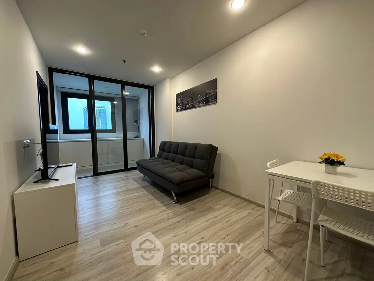 Modern living room with sleek sofa and dining area in contemporary apartment.