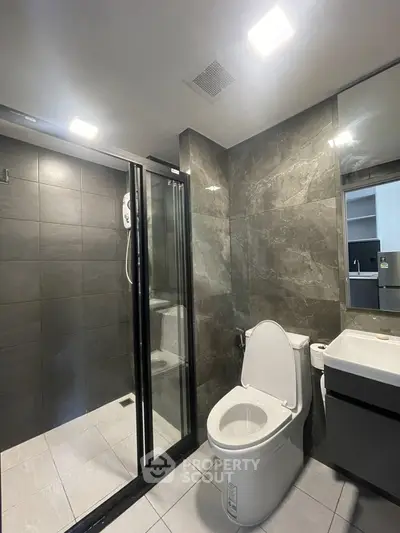 Modern bathroom with sleek shower and elegant fixtures in a contemporary apartment.