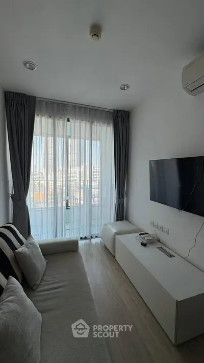 Modern living room with sleek design and city view through large window.