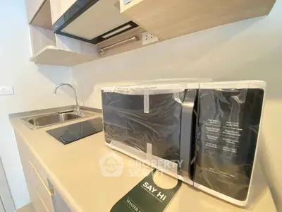 Modern kitchen with sleek appliances and stylish cabinetry in a contemporary apartment.