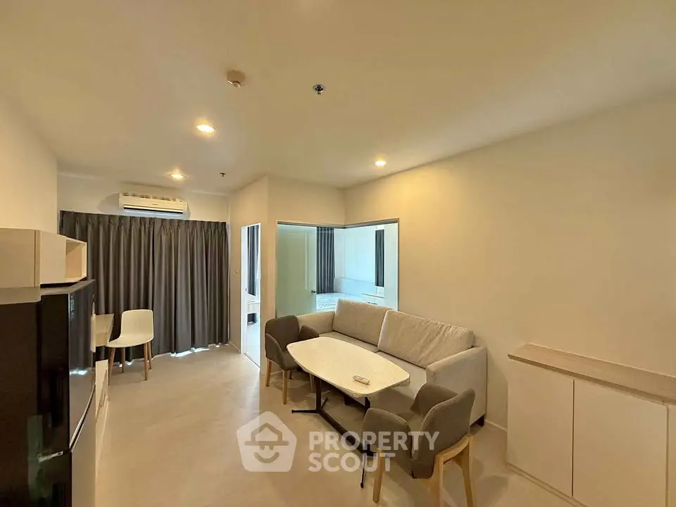 Modern living room with cozy seating and natural light in a stylish apartment.