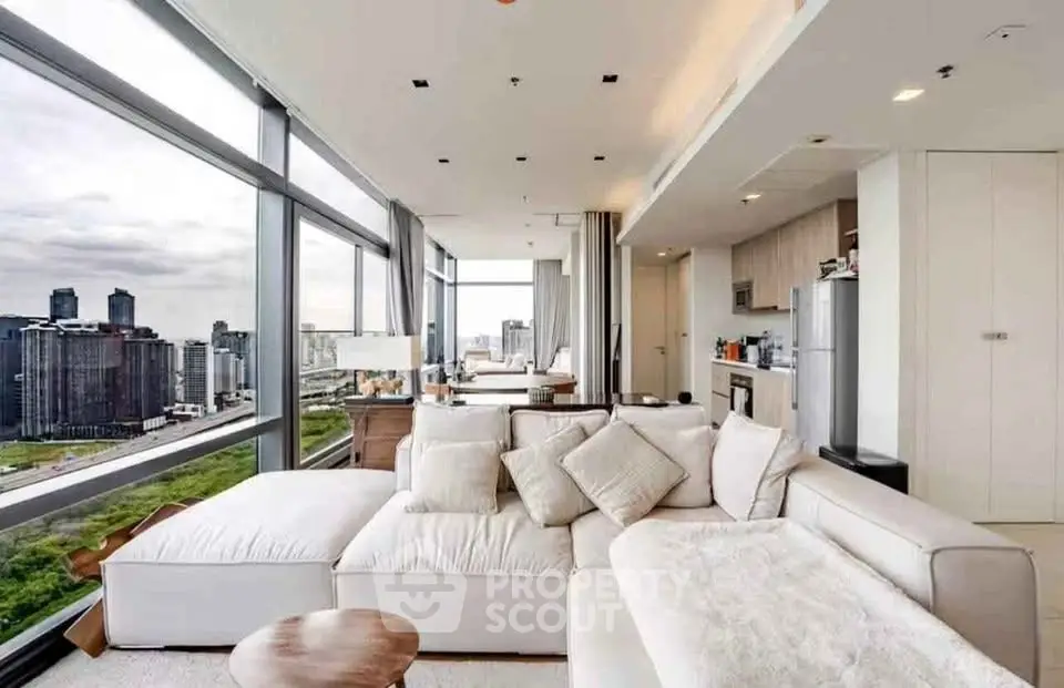 Luxurious modern living room with panoramic city views and elegant white furnishings.