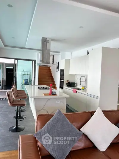 Modern open-plan kitchen with sleek design and island seating in a stylish home interior.