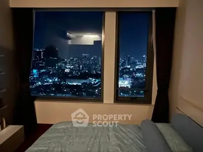 Luxurious bedroom with stunning city skyline view at night, perfect for urban living.