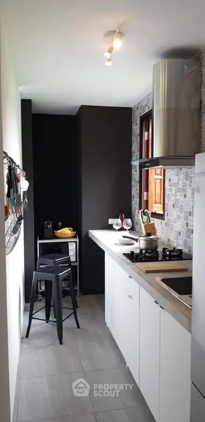 Modern kitchen with sleek design, featuring gas stove and stylish backsplash, perfect for culinary enthusiasts.