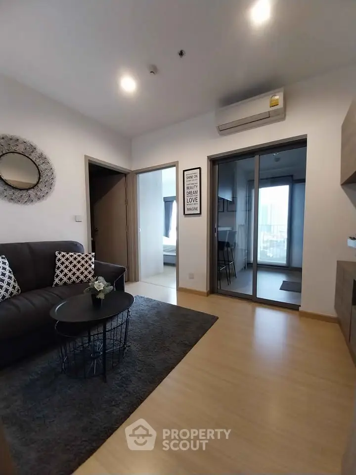Modern living room with stylish decor and open view to bedroom and kitchen