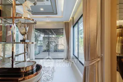 Luxurious living room with large windows and elegant decor, offering a seamless indoor-outdoor experience.