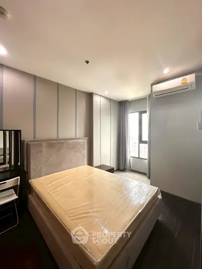 Modern bedroom with stylish decor and natural light, featuring a comfortable bed and air conditioning.