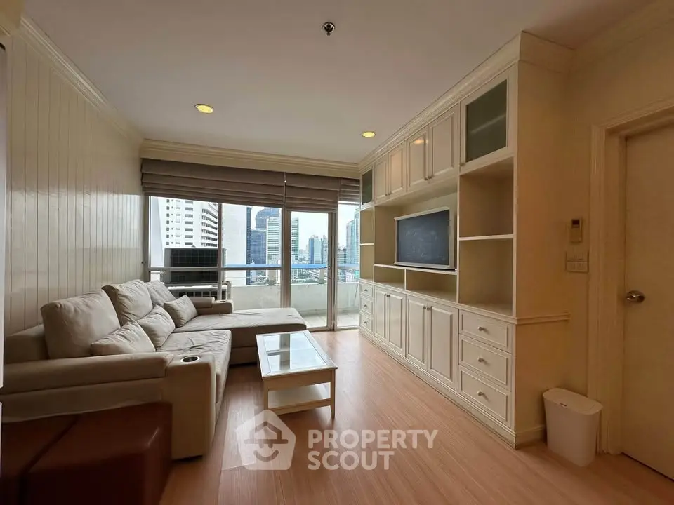 Spacious living room with city view, modern furniture, and built-in entertainment center.