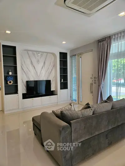 Luxurious living room with modern decor and plush gray sofa, perfect for relaxation.