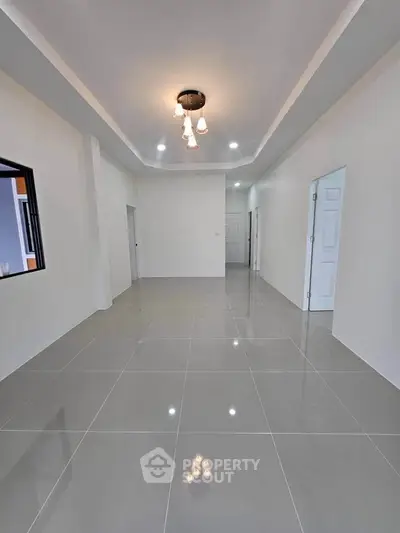 Spacious modern living room with elegant lighting and glossy tiled flooring