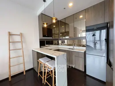 Modern kitchen with sleek design, featuring a breakfast bar and stylish pendant lighting.