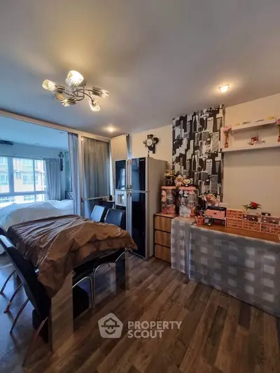Stylish modern living room with dining area and unique lighting fixture, featuring wood flooring and contemporary decor.
