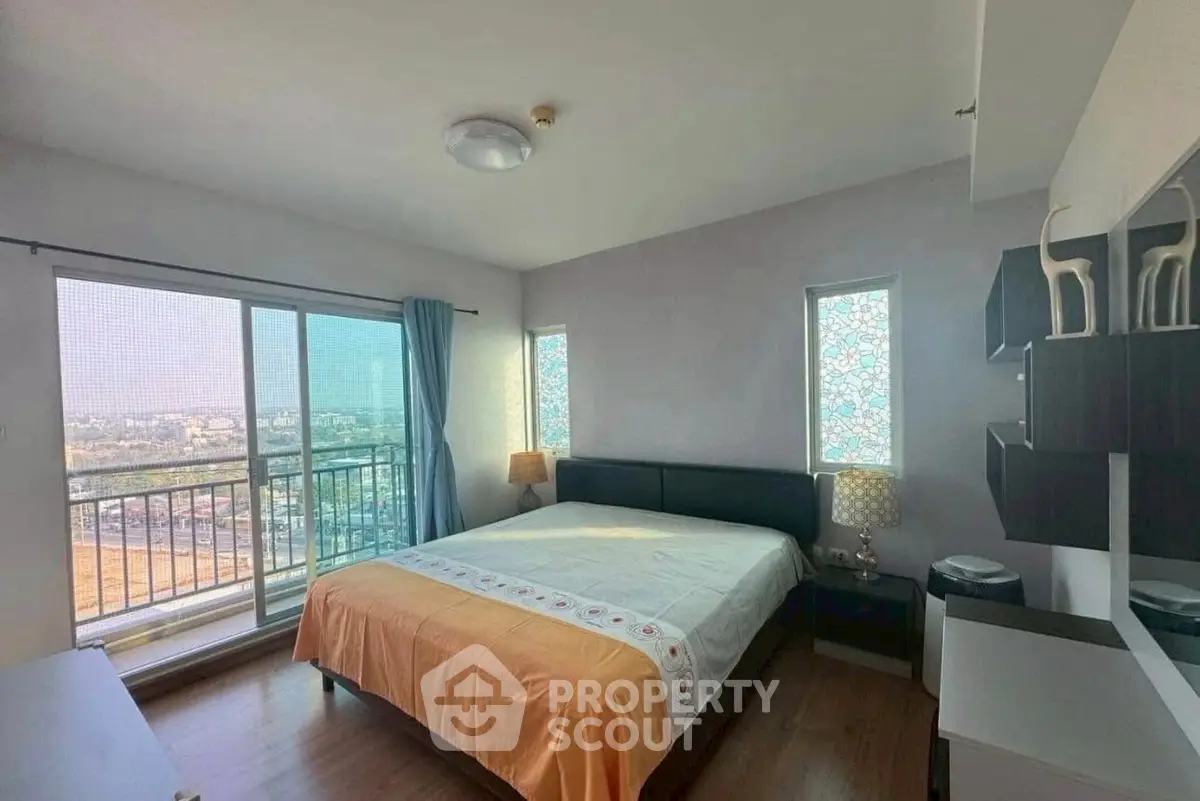 Bright bedroom with large windows and city view, featuring modern decor and ample natural light.
