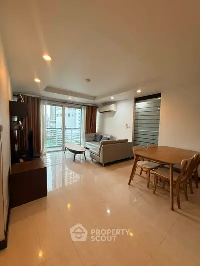 Spacious modern living room with dining area and natural light.