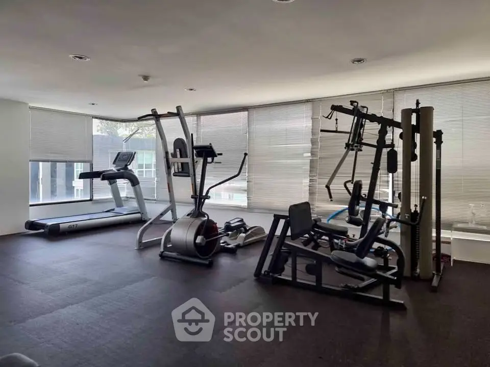 Modern gym with state-of-the-art fitness equipment and large windows for natural light.