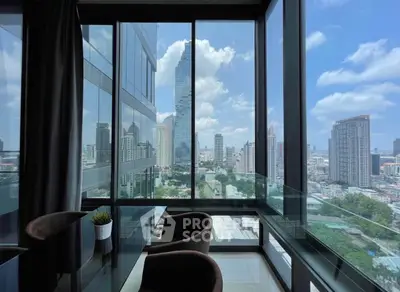 Stunning city view from modern high-rise apartment with floor-to-ceiling windows.