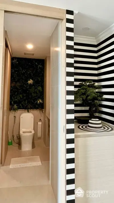 Modern bathroom with striped walls and greenery accent