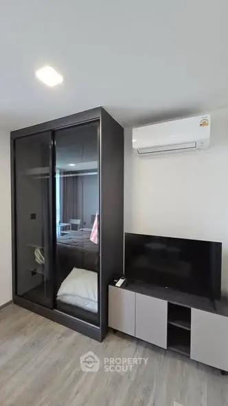 Modern bedroom with sleek wardrobe and air conditioning unit, perfect for comfortable living.