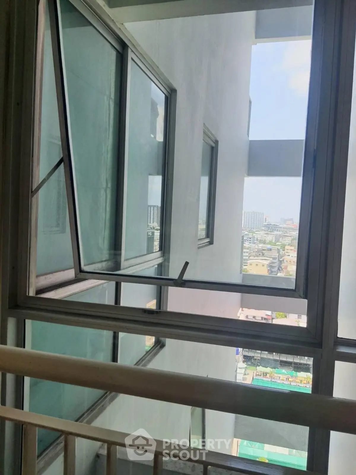 Modern building with open windows offering a city view, showcasing urban living.