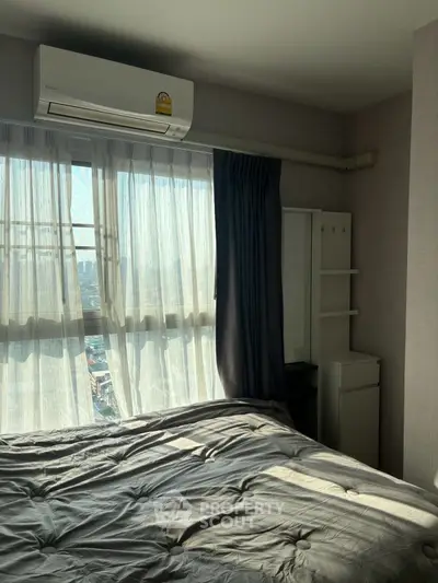 Cozy bedroom with large window and air conditioning, offering a bright and inviting atmosphere.