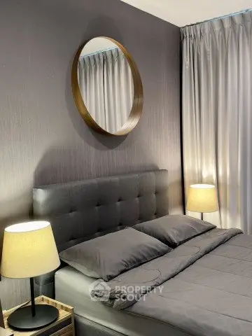 Modern bedroom with stylish decor and cozy lighting, featuring a plush bed and elegant curtains.