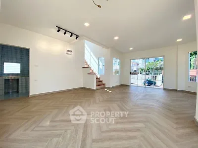 Spacious modern living room with herringbone flooring and natural light