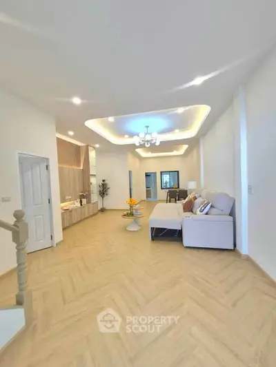 Spacious modern living room with elegant lighting and cozy seating area, perfect for relaxation and entertainment.