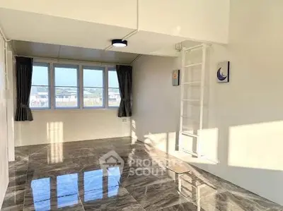 Bright and spacious room with glossy marble flooring and large windows.