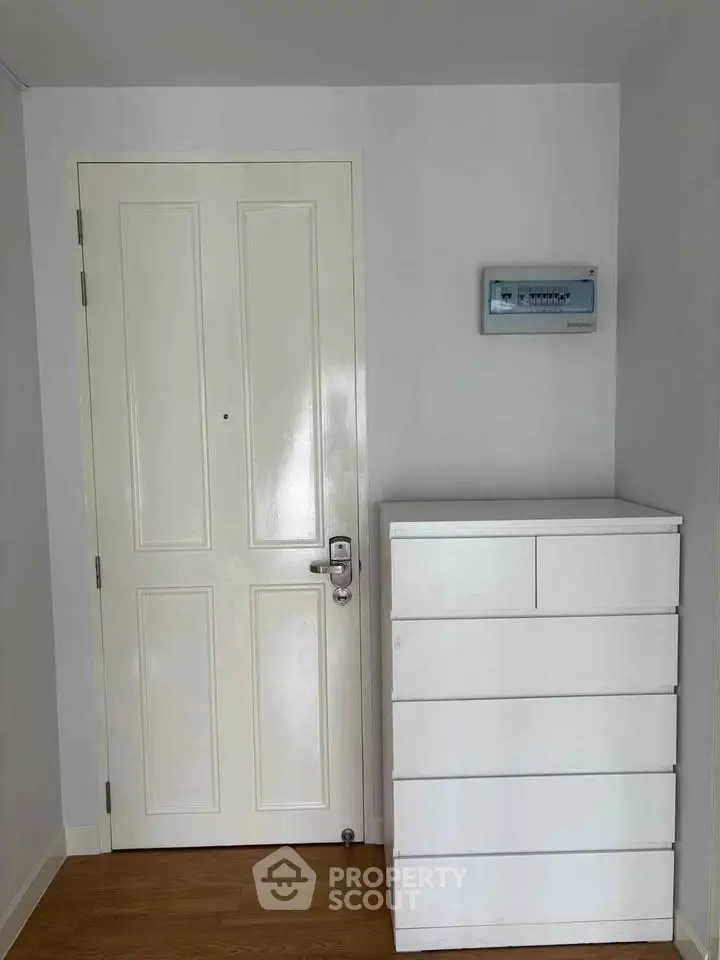 Modern white interior with sleek door and storage unit, perfect for minimalist living.