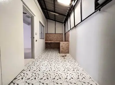 Spacious utility area with tiled flooring and brick accents, perfect for laundry or storage needs.
