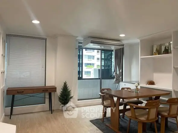 Modern dining area with wooden furniture and large window in a stylish apartment