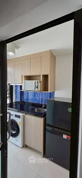 Modern kitchen with sleek appliances and stylish blue backsplash