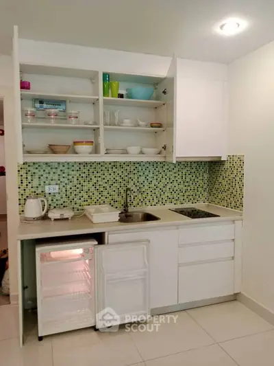 Modern kitchen with open shelving and compact fridge in stylish apartment