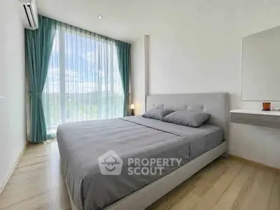 Spacious bedroom with large window and modern decor in a bright apartment.