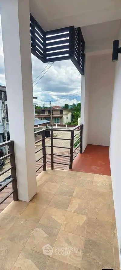 Spacious balcony with modern railing and city view, perfect for relaxation.