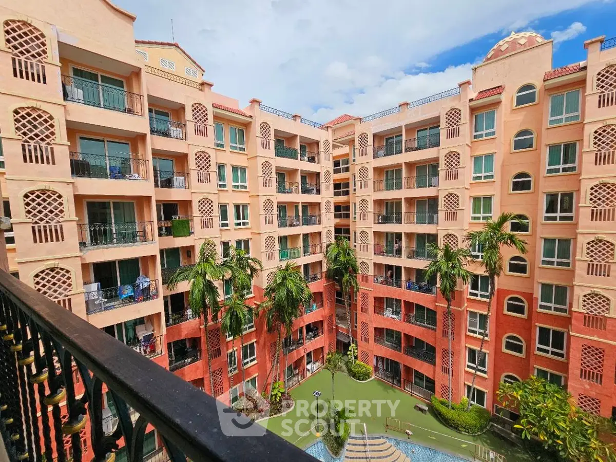 Charming Mediterranean-style apartment complex with lush courtyard and pool view.