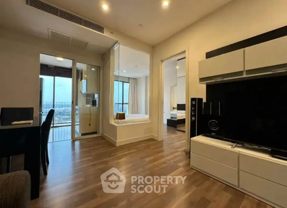 Modern living room with wooden flooring, open layout, and balcony view in a stylish apartment.