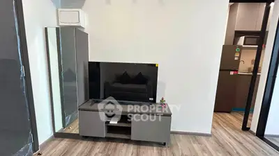 Modern living room with sleek TV stand and mirrored cabinet, showcasing contemporary interior design.