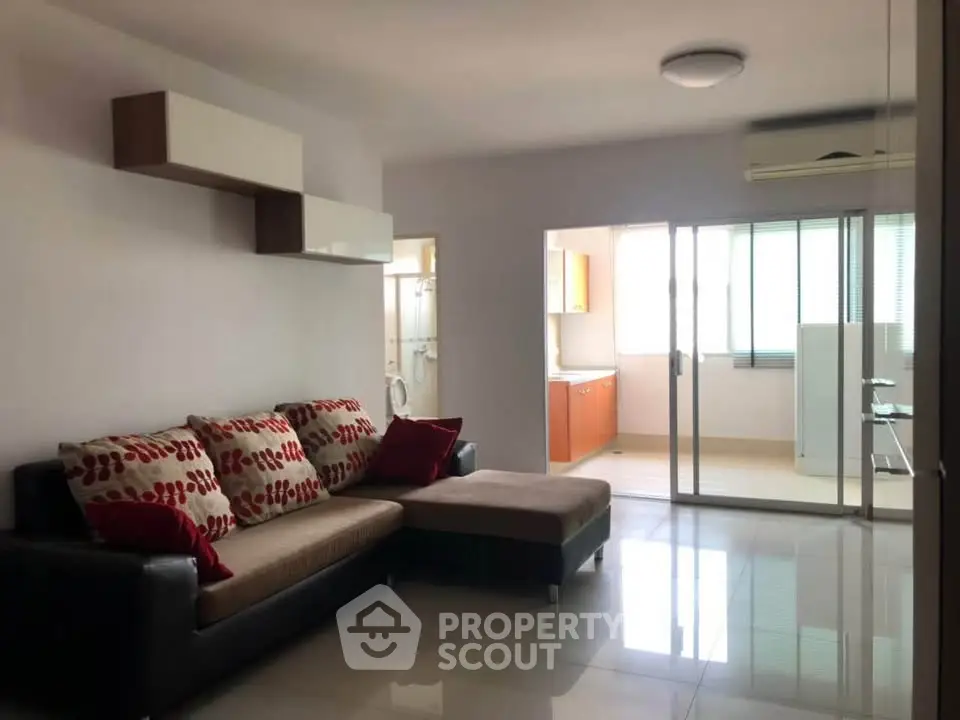 Spacious living room with modern decor and open kitchen layout in a bright apartment.