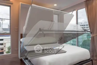 Modern bedroom with innovative foldable bed design and large windows offering city views.