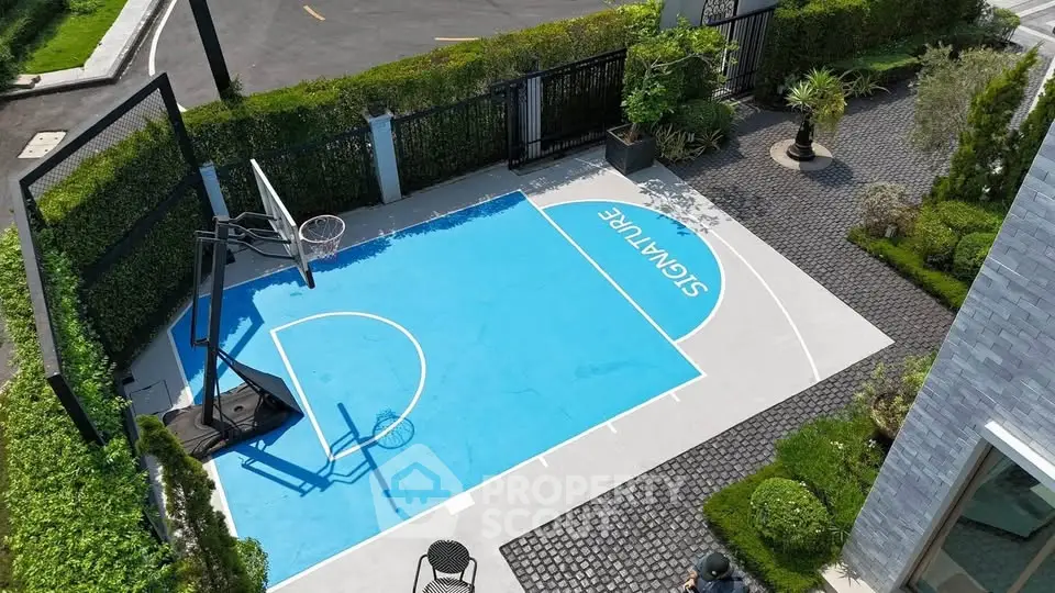 Modern outdoor basketball court in a residential area with lush greenery and stylish design.