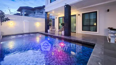 Luxurious modern home with illuminated pool and elegant patio, perfect for evening relaxation.