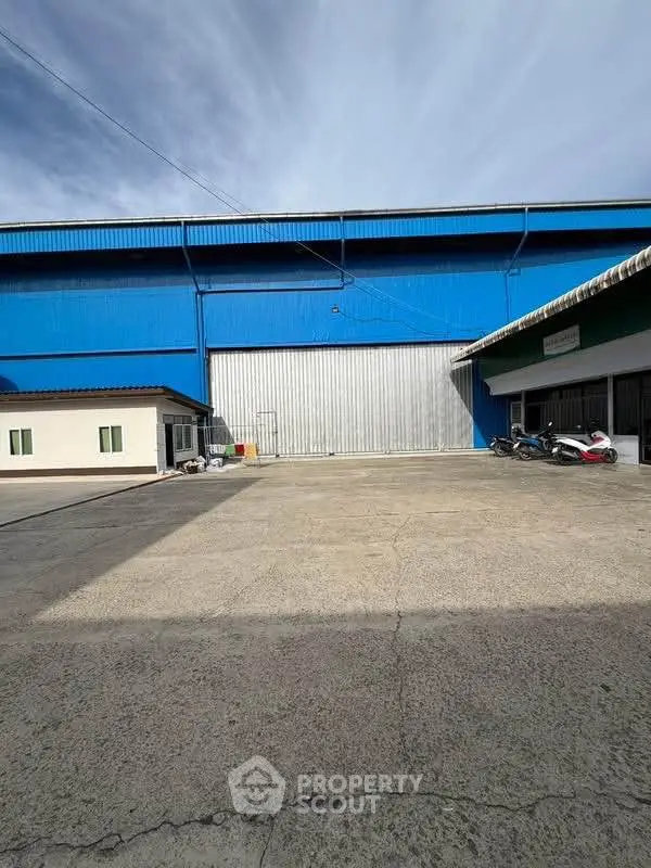 Spacious industrial warehouse with large loading area and secure entrance, ideal for logistics and storage solutions.