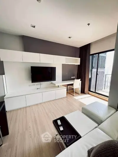Modern living room with sleek furniture and balcony access in a stylish apartment.