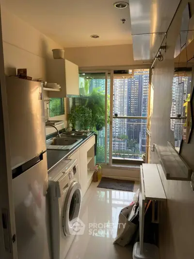 Compact kitchen with washing machine and city view from window