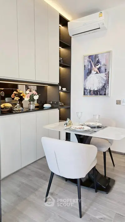 Modern kitchen with sleek cabinetry and cozy dining area, featuring elegant decor and contemporary design.